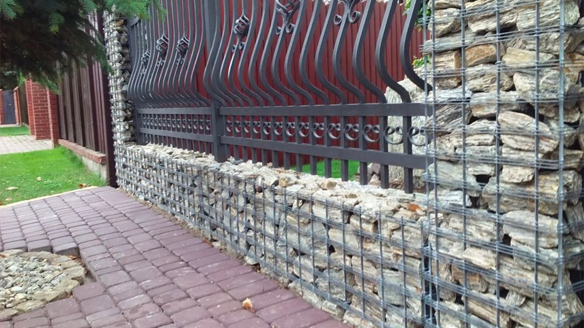 Gabion Vision en piliers de 400 x 1690 mm permettant l'installation de la porte d'entrée de la résidence. www.gabion-design.com - <p>Utilisation de Gabion Vision en piliers de 400 x 1690 mm permettant l’installation de la porte d’entrée de la résidence.<br class='autobr' />
Modules Gabion Vision de hauteur 350 mm Longueur 2000 mm comme support pour clôture en fer forgé. Une très belle association du minéral et du métal.</p>